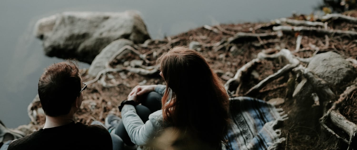couple-sitting-by-lake