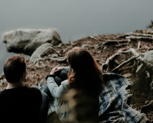 couple-sitting-by-lake