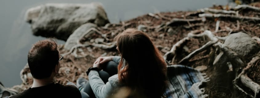 couple-sitting-by-lake